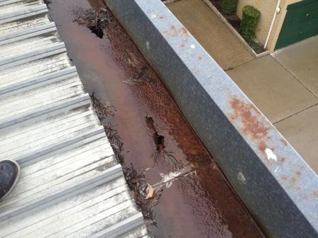 Severely rusted gutter with holes