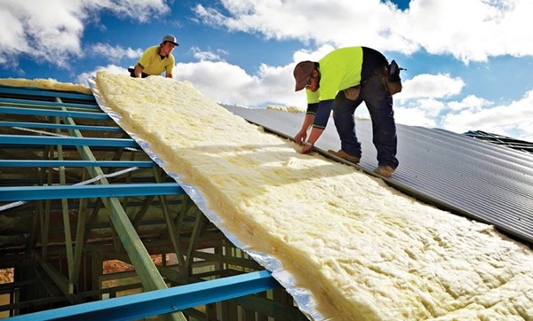 Roofers installing anti-condensation blanket