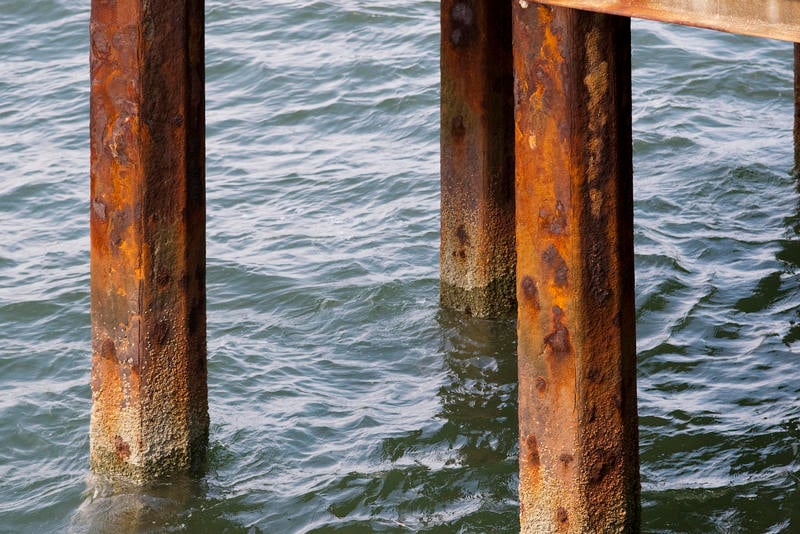 Rusted pier supports in ocean