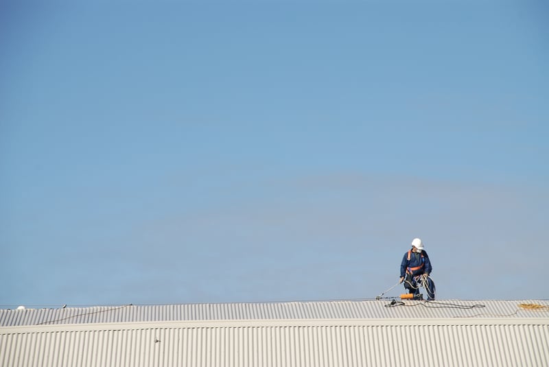 Roofer using harness on roof